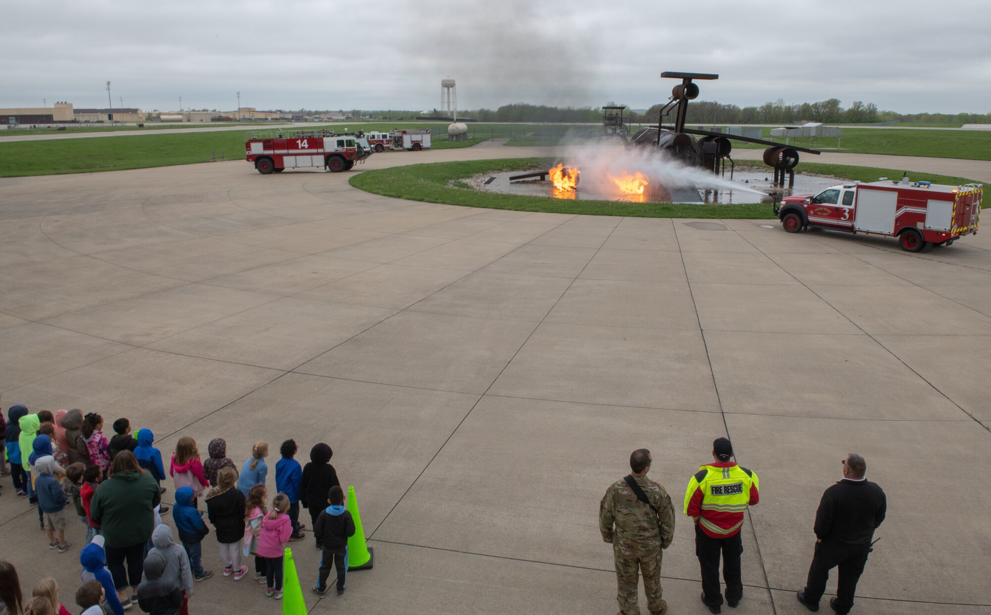 Fire protection specialists assigned to the 509th Civil Engineering Squadron conduct a training demonstration for a group of kindergarteners from Whiteman Elementary School during a base field trip on Whiteman Air Force Base, Missouri, May 4, 2022. The students toured various facilities on base receiving demonstrations from security forces and the fire department. (U.S. Air Force photo by Airman 1st Class Bryson Britt)