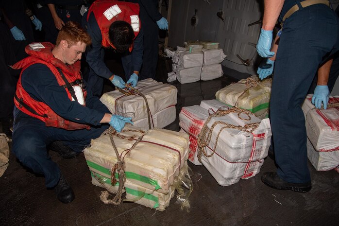 220516-N-TT059-1007 GULF OF OMAN (May 16, 2022) Sailors aboard guided-missile destroyer USS Momsen (DDG 92) process bags of illegal narcotics May 16. The drugs were seized from a fishing vessel in the Gulf of Oman.