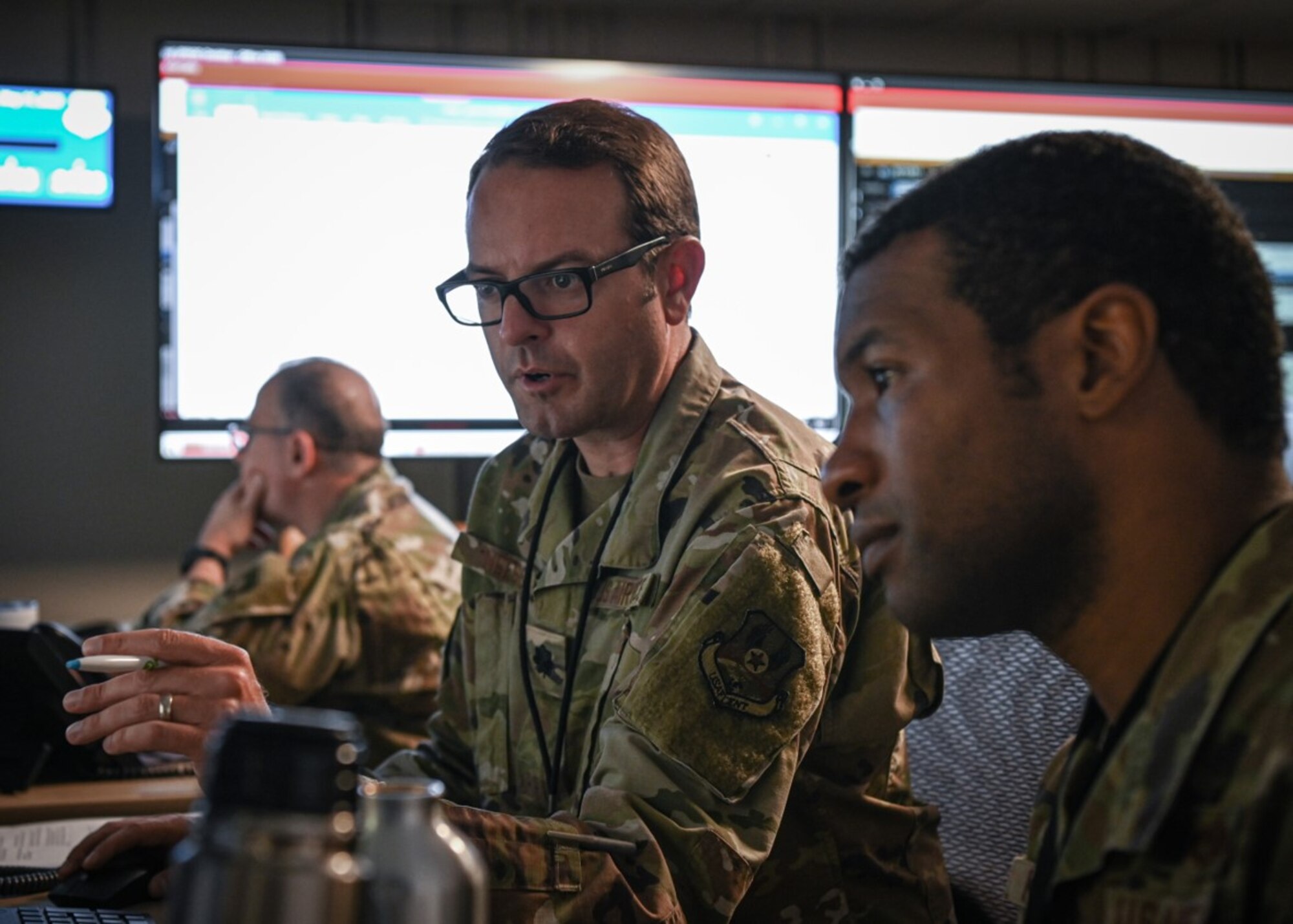 U.S. Air Force Lt. Col. Jay Neese, left, and Maj. William Keuchler, Ninth Air Force (Air Forces Central) Exercise Crisis Action Team deputy directors, review exercise procedures during an Air and Missile Defense Exercise at Shaw Air Force Base, South Carolina, May 11, 2022. AMDEX is a semi-annual exercise that develops and fortifies procedures against simulated air and missile threats in addition to strengthening dispersed operations capabilities. (U.S. Air Force photo by Staff Sgt. Draeke Layman)