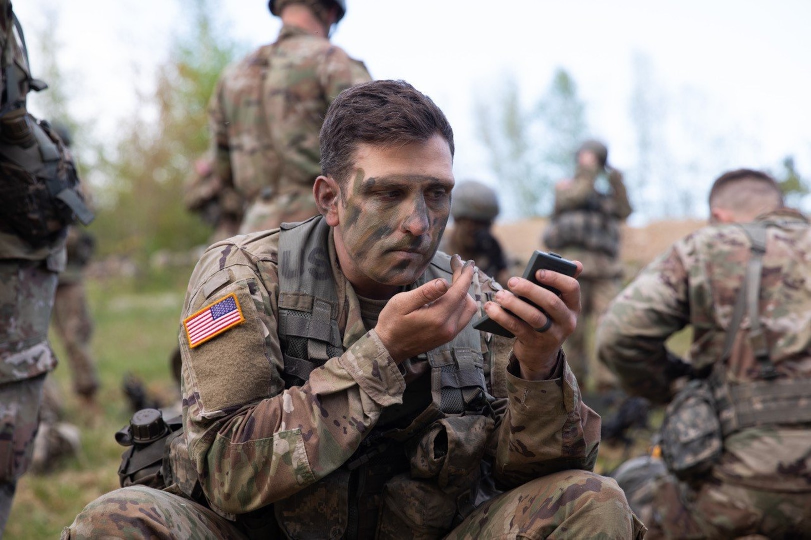 Officer Candidate Blake Costa of the Rhode Island Army National Guard applies face paint at the start of day two of the Region 1 Officer Candidate School Field Leadership Exercise on May 14, 2022, in Center Strafford, N.H.
