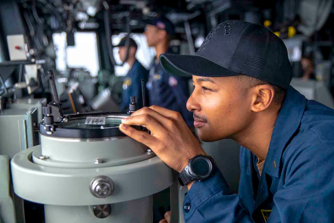 A sailor stands watch aboard a ship.