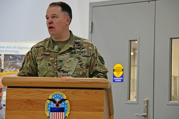 Man in uniform stands at podium and speaks