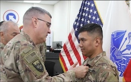 Soldier receives medal from a general officer