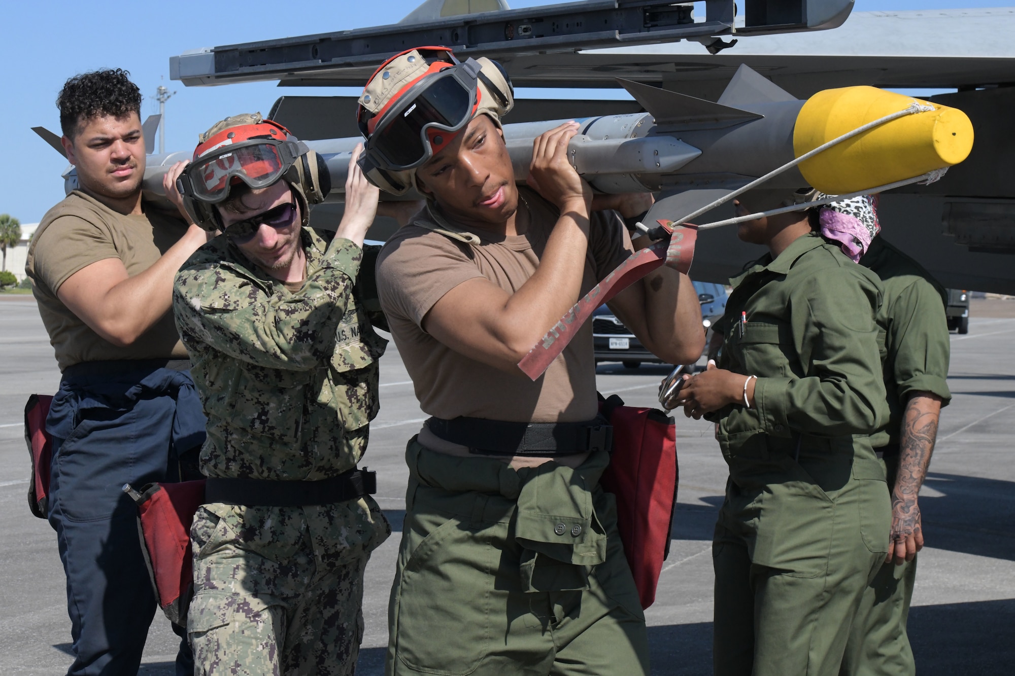 U.S. Sailors assigned to Strike Fighter Squadron (VFA) 83 remove an AIM-9X Sidewinder missile from an F/A-18E Super Hornet at Tyndall Air Force Base, Florida, May 10, 2022.