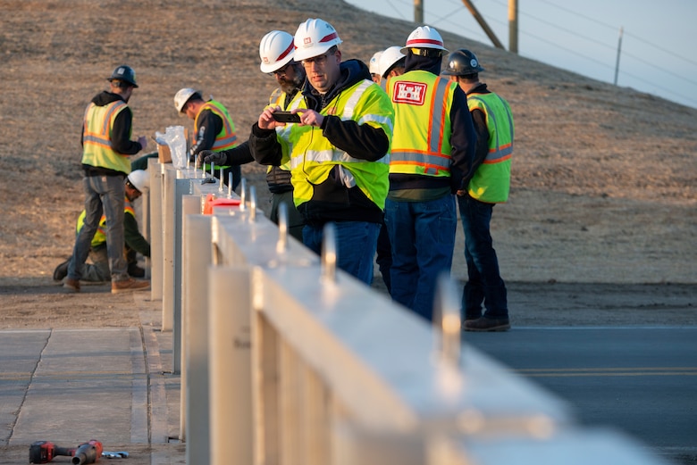 US Army Corps of Engineers, Omaha District members inspect the installation of flood gate panels along the highway leading to Hamburg Iowa, 24 Apr., 2022.