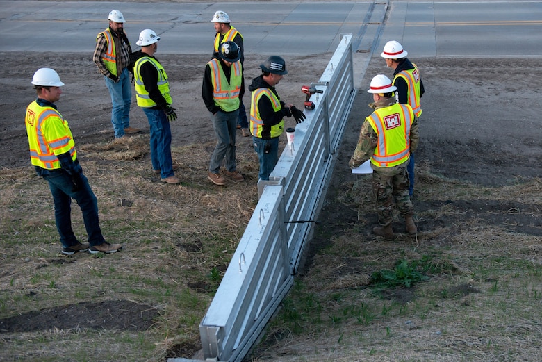U.S. Army Corps of Engineers, Omaha District members inspect the installation of flood gate panels along the highway leading to Hamburg Iowa, 24 Apr., 2022.