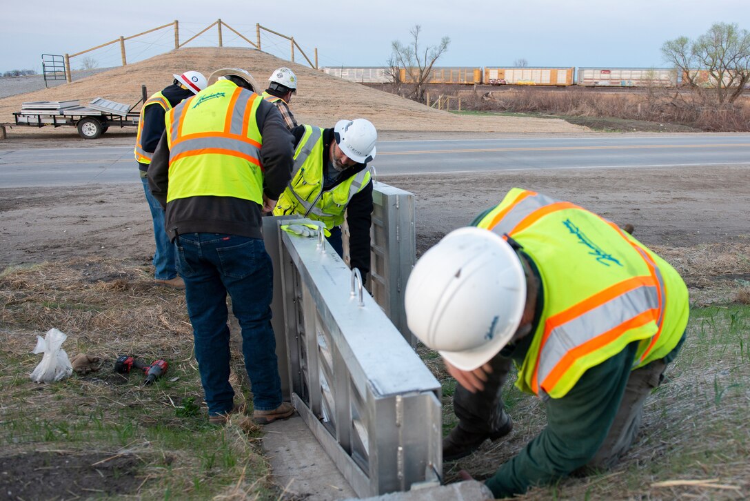 US Army Corps of Engineers, Omaha District members inspect the installation of flood gate panels along the highway leading to Hamburg Iowa, 24 Apr., 2022