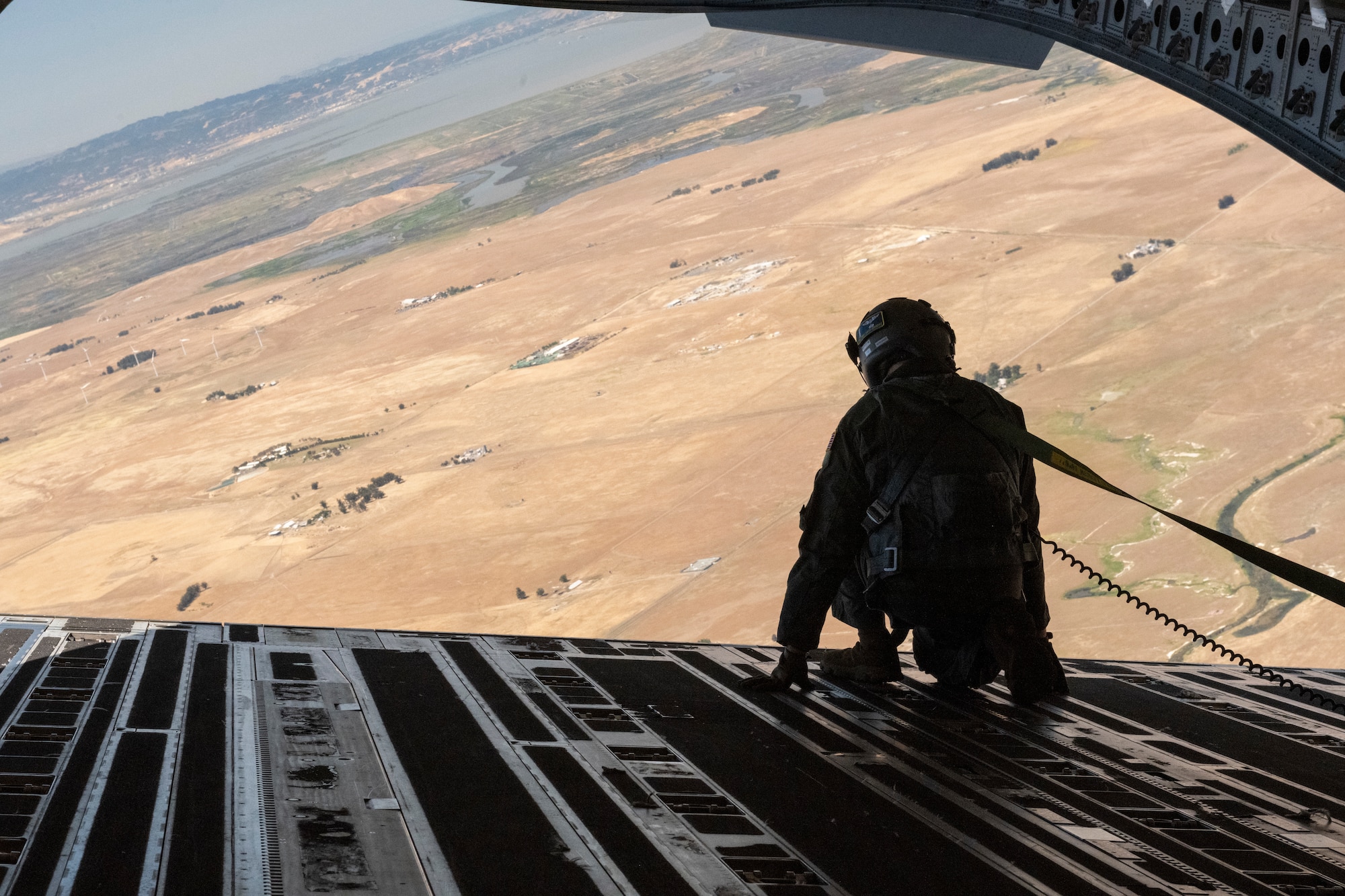 An airman looks over an aircraft ramp in flight