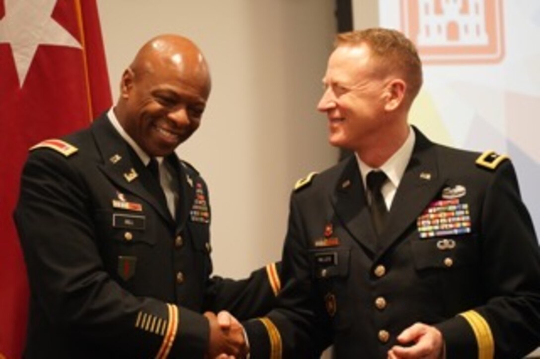 Chief Warrant Officer 5 Corey Hill shakes hands with a fellow Army officer at his retirement ceremony.