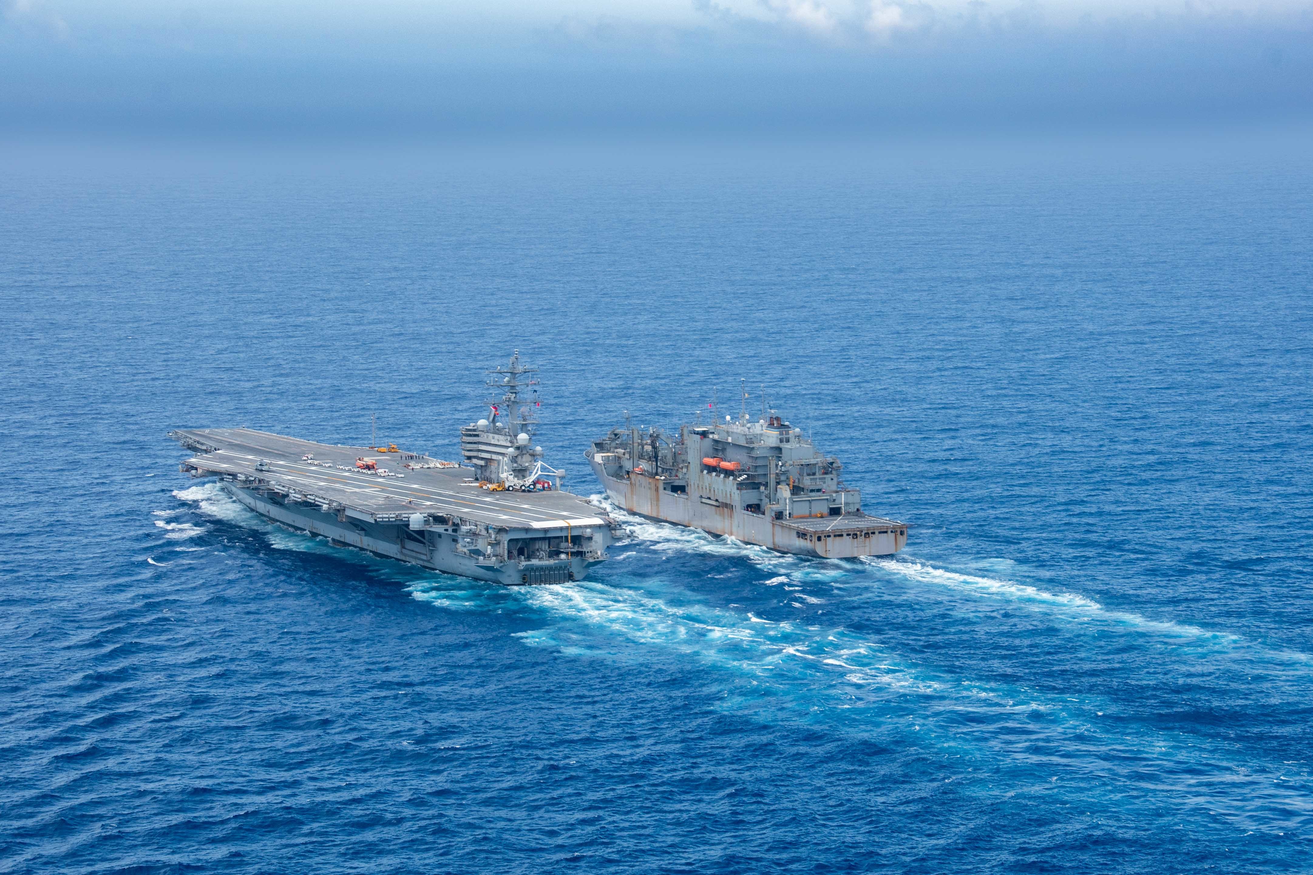 The U.S. Navy's only forward-deployed aircraft carrier USS Ronald Reagan (CVN 76) steams alongside the Military Sealift Command dry cargo and ammunition ship USNS Amelia Earhart (T-AKE 6)