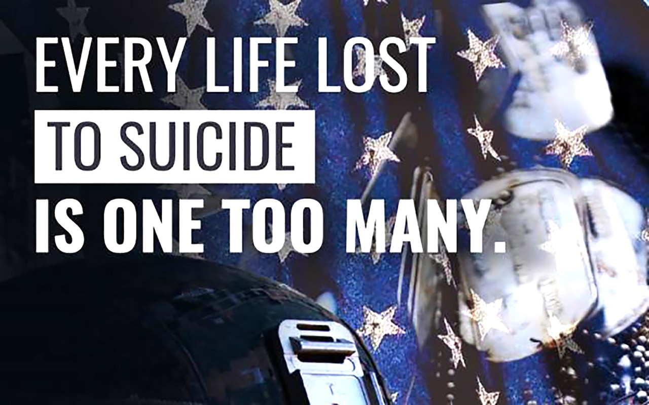 A helmet, dog tags and a flag is shown. Words read "Every life lost to suicide is one too many."