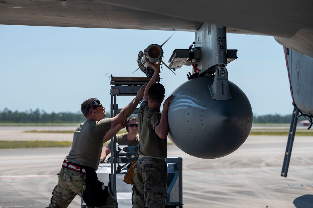 Airmen load missiles onto an aircraft