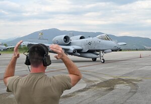 U.S. Air Force Staff Sgt. Dylan Martin, crew chief assigned to the 175th Aircraft Maintenance Squadron, guides an A-10C Thunderbolt II aircraft assigned to the 104th Fighter Squadron, Maryland Air National Guard, in Ohrid, North Macedonia, May 7, 2022, to conduct Agile Combat Employment training in support of the Swift Response exercise. The purpose of the exercise is to present combat-credible Army forces in Europe and Africa and enhance readiness by building airborne interoperability with allies and partners.