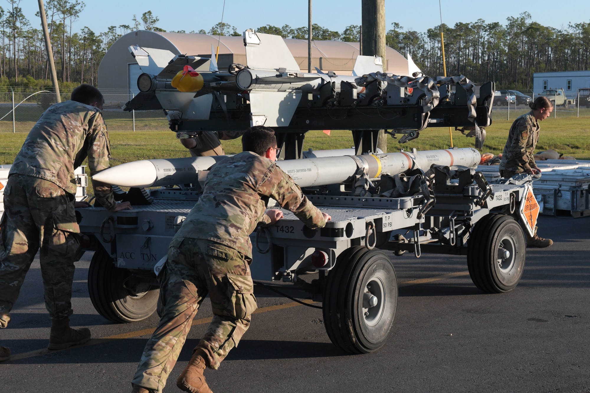 U.S. Airmen with the 325th Munitions Squadron push a munitions handling trailer at Tyndall Air Force Base, Florida, May 10, 2022.