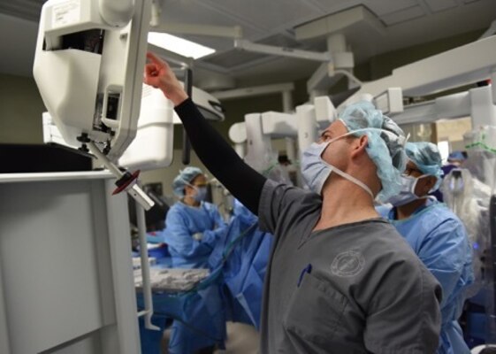 Maj. William Scott, 99th Surgical Operations Squadron general surgeon, shows a trainee how a da Vinci Surgery System works while performing surgery at the Mike O’ Callaghan Medical Center on Nellis Air Force Base, Nev., April 3, 2019. The da Vinci was used to perform the surgery, allowing the patient a faster recovery time. (U.S. Air Force photo by Airman 1st Class Bryan Guthrie)