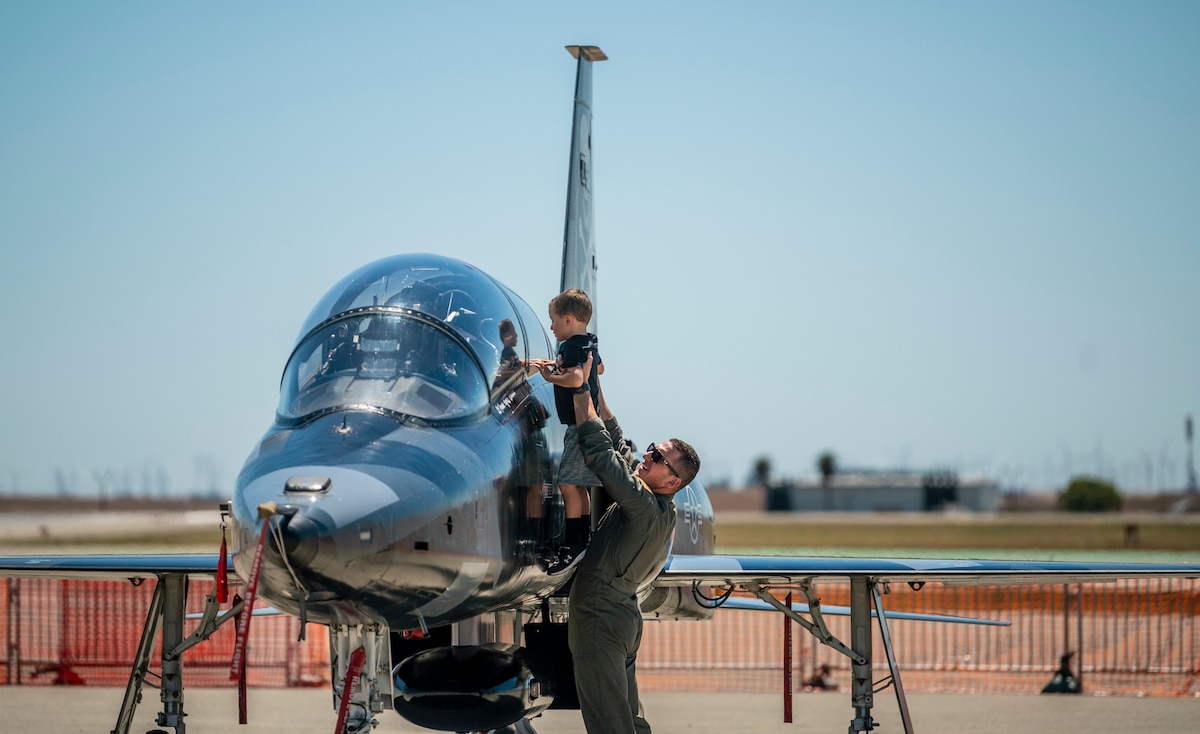First Lt. Ryan Durgarian, 70th Air Refueling Squadron KC-10 Extender pilot, raises his son Luke, to get a better view of a T-38C during the Wings Over Solano open house and air show rehearsal at Travis Air Force Base, Calif., May 13, 2022. The air show rehearsal provided an opportunity for Department of Defense employees and their families to see the installation’s full capabilities. (U.S. Air Force photo by Senior Airman Karla Parra)