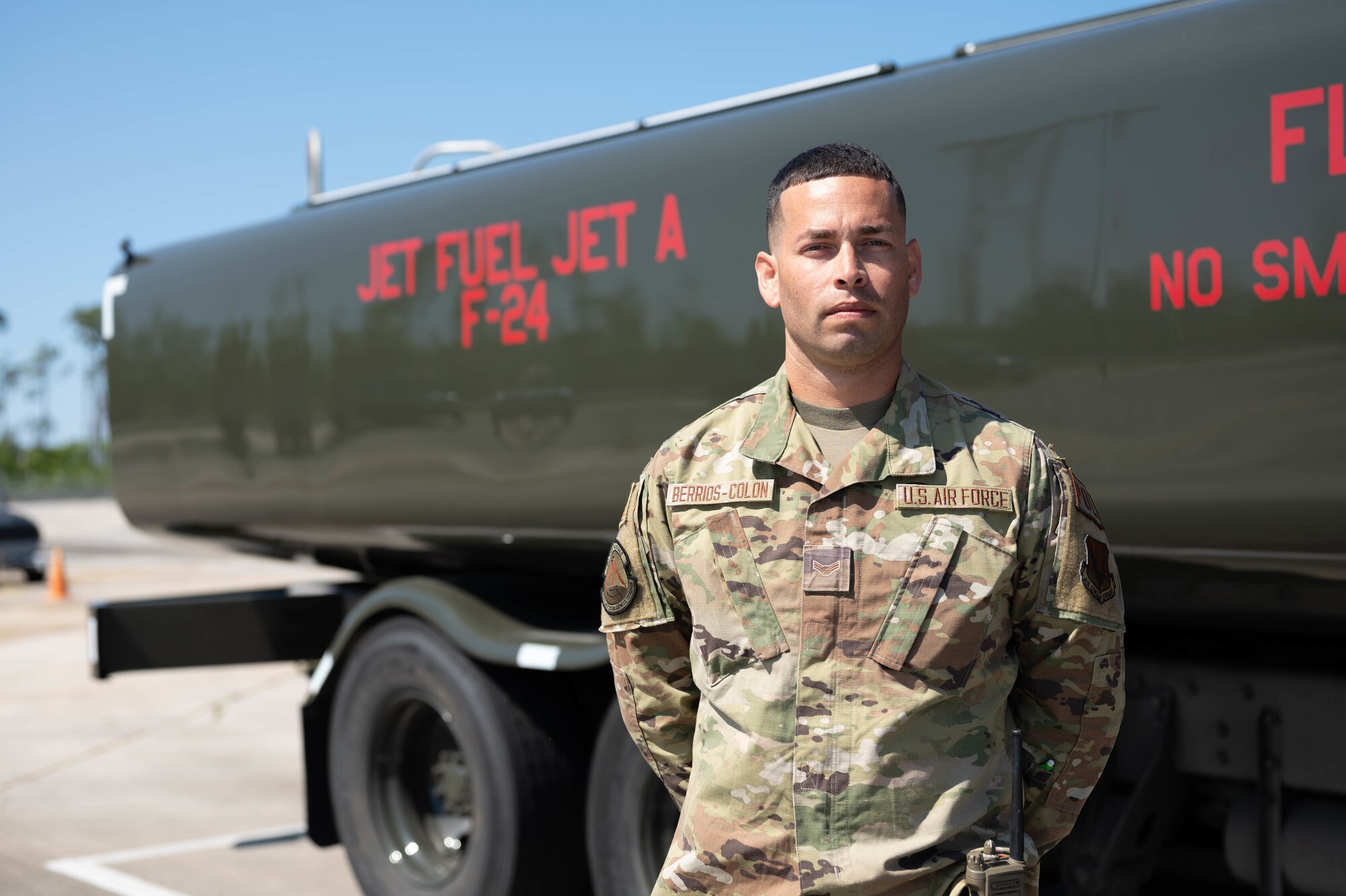 An Airman poses for a portrait in front of a fuels distribution truck