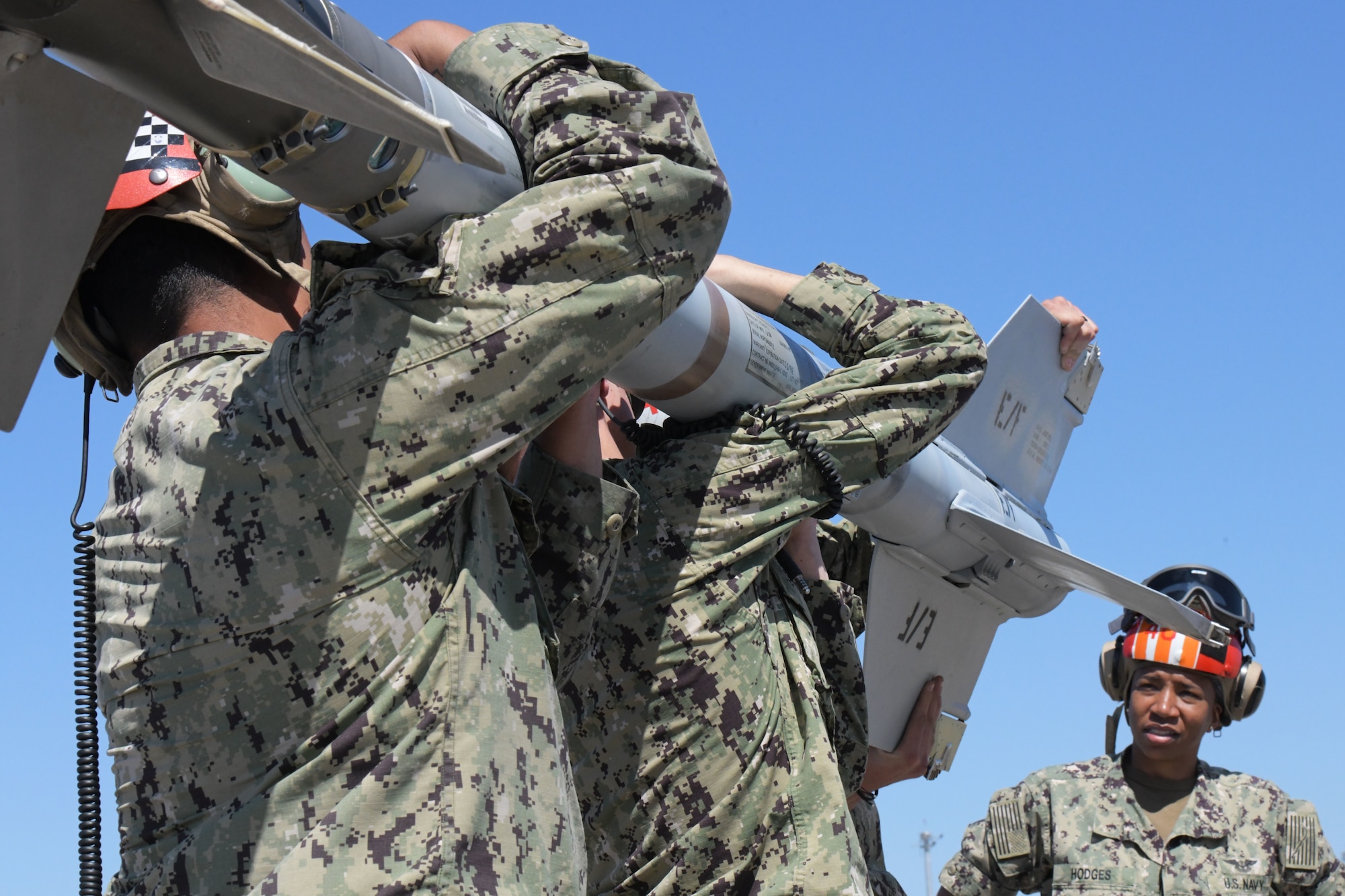 U.S. Sailors assigned to Strike Fighter Squadron (VFA) 83 carry an AIM-9M Sidewinder missile to an F/A-18E Super Hornet at Tyndall Air Force Base, Florida, May 10, 2022.