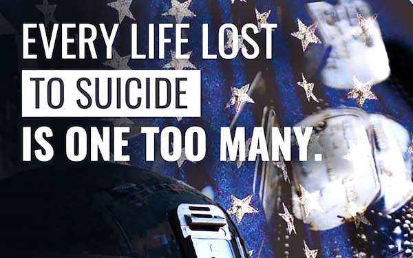 A helmet, dog tags and a flag is shown. Words read "Every life lost to suicide is one too many."
