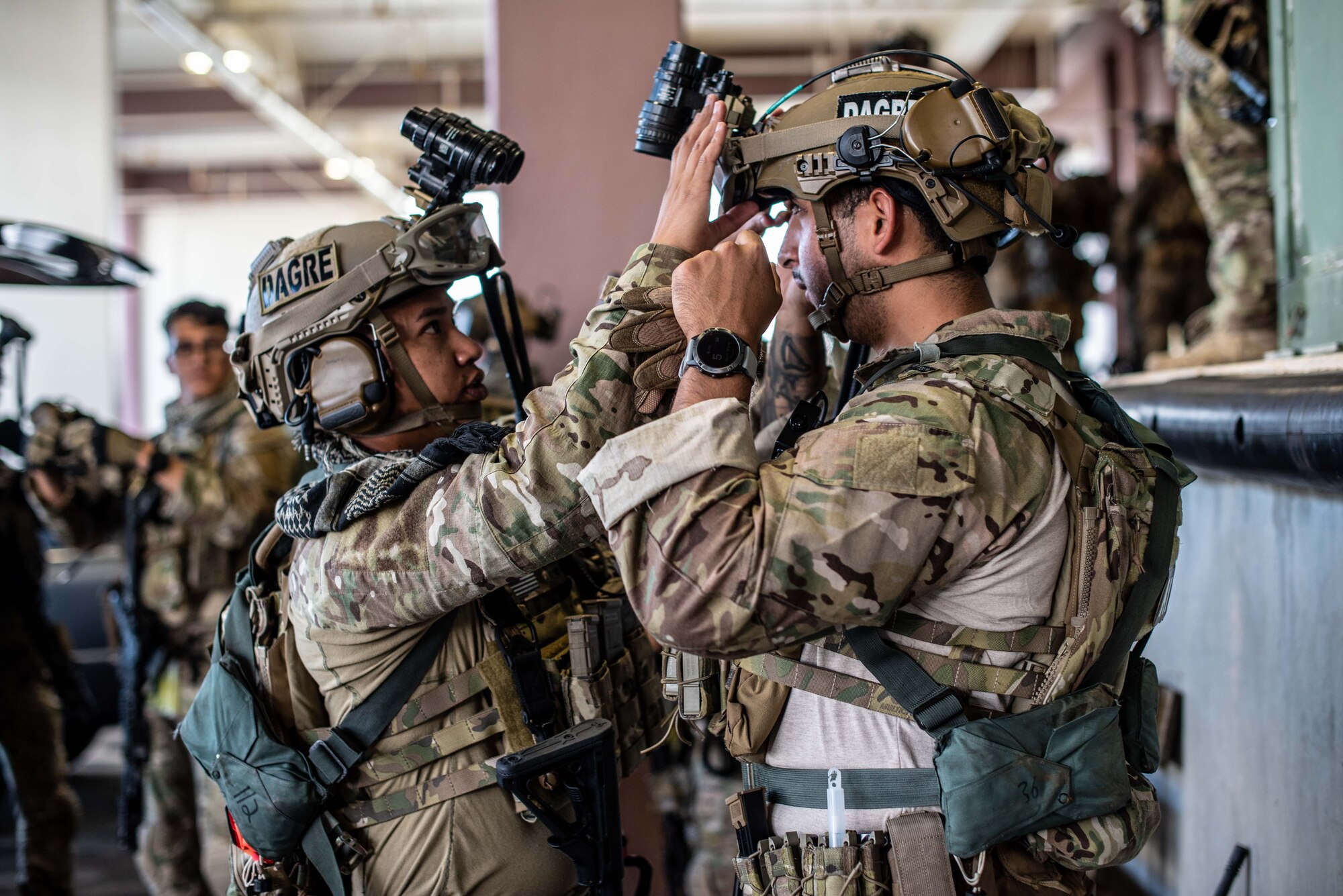 Airmen prepare each other's gear.