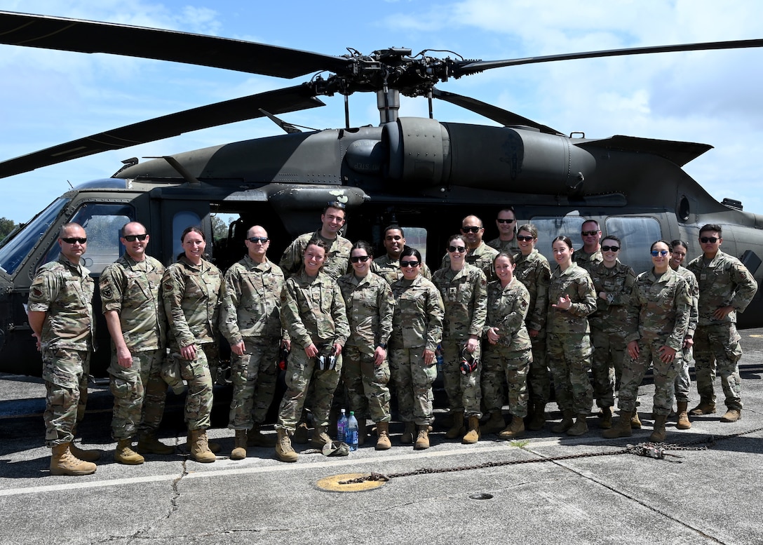 Members from the 104th Medical Group stand in front of an Army UH-60 Black Hawk helicopter before a morale flight at Wheeler Army Airfield, Hawaii, May 3, 2022. Airmen are in Hawaii to complete training requirements at Tripler Army Medical Center. (U.S. Air National Guard Photo by Senior Airman Camille Lienau)
