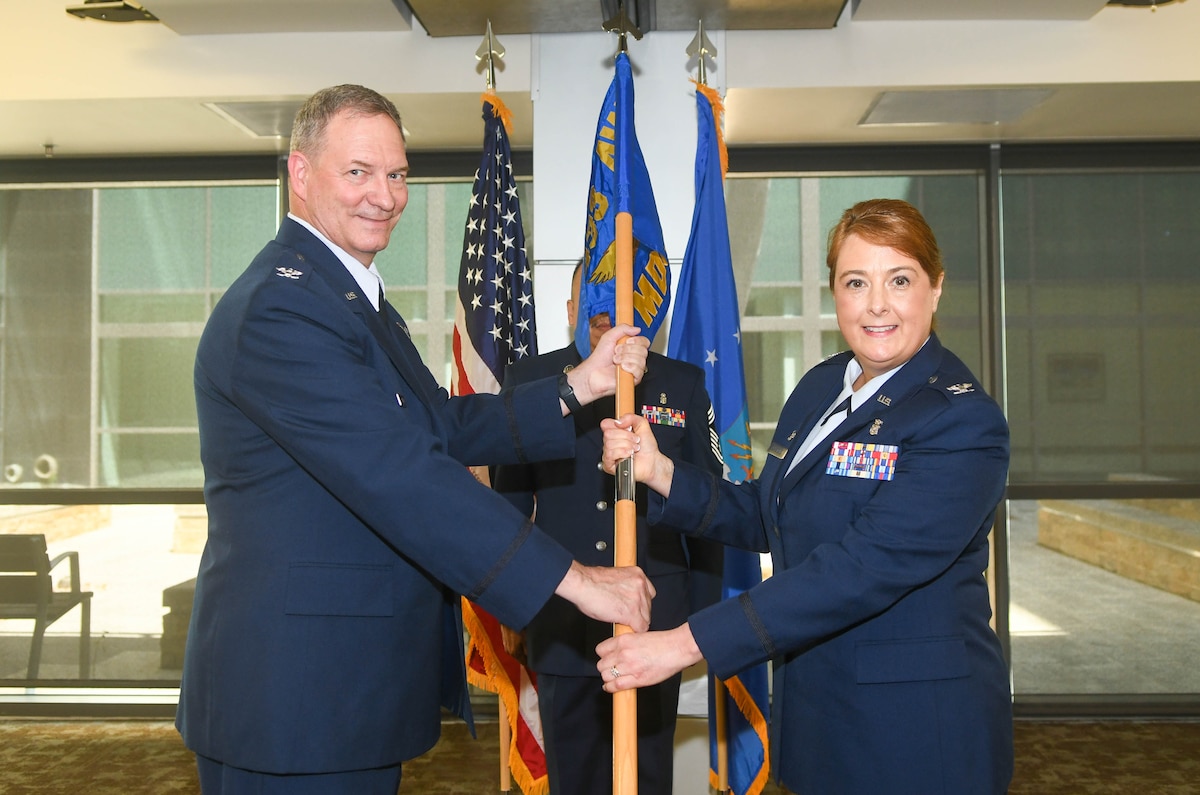 Col. Terry McClain, 433rd Airlift Wing commander, presents the guidon to Col. Michelle Van Sickle during the 433rd Medical Group assumption of command ceremony at Wilford Hall Ambulatory Surgical Center, Joint Base San Antonio-Lackland, Texas, May 14, 2022. Van Sickle was previously the 914th Aeromedical Evacuation Squadron commander at Niagara Falls Air Reserve Station, New York. (U.S. Air Force photo by Airman 1st Class Mark Colmenares)