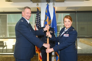 Col. Terry McClain, 433rd Airlift Wing commander, presents the guidon to Col. Michelle Van Sickle during the 433rd Medical Group assumption of command ceremony at Wilford Hall Ambulatory Surgical Center, Joint Base San Antonio-Lackland, Texas, May 14, 2022. Van Sickle was previously the 914th Aeromedical Evacuation Squadron commander at Niagara Falls Air Reserve Station, New York. (U.S. Air Force photo by Airman 1st Class Mark Colmenares)