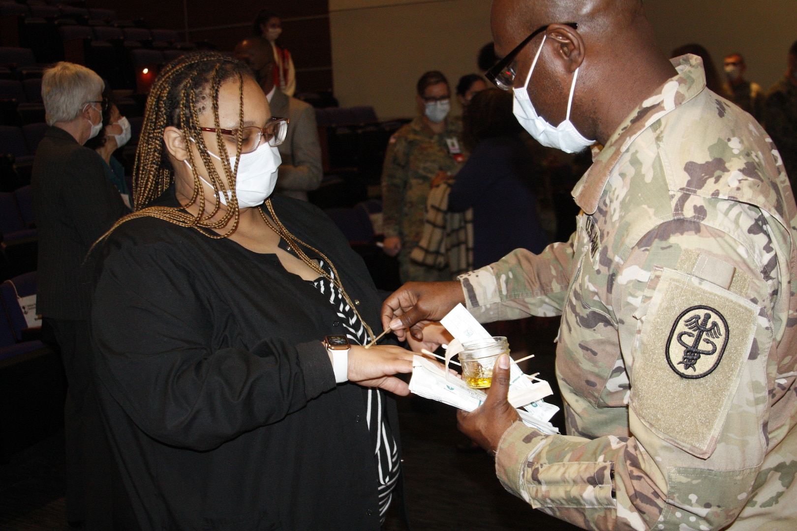 Chaplain blesses the hands of a nurse