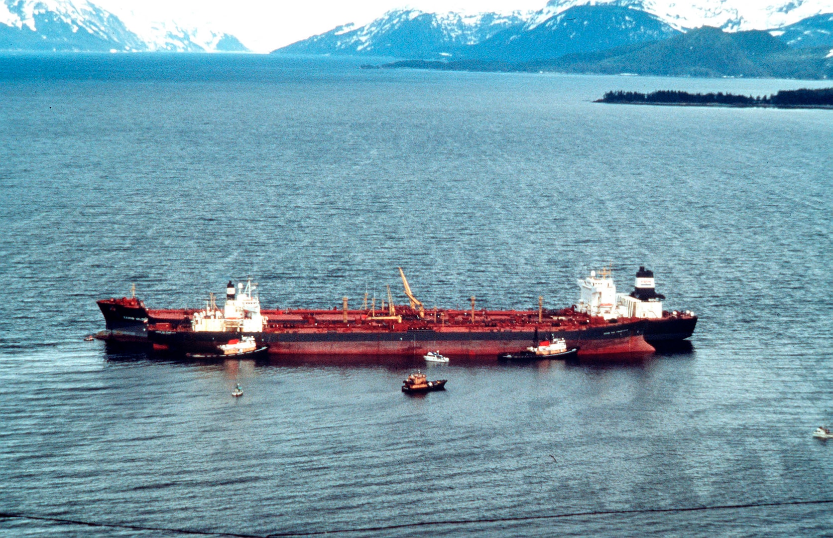 Prince William Sound, AK (Mar. 24)--The Exxon Valdez remains in place in Prince Williams Sound after running aground.  The Exxon Valdez ran aground on Bligh Reef in Prince William Sound, Alaska, March 23, 1989 spilling 11 million gallons of crude oil, which resulted in the largest oil spill in U.S. history.  U.S. COAST GUARD PHOTO