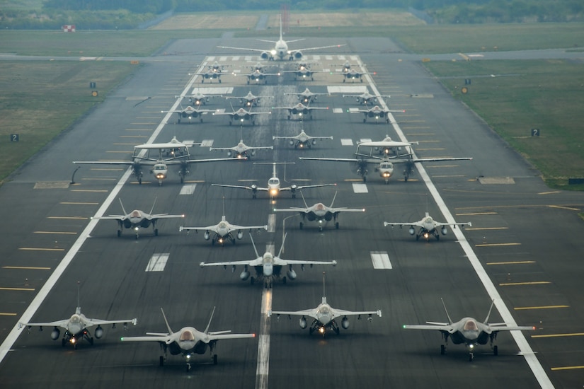 A large group of aircraft taxi in formation.