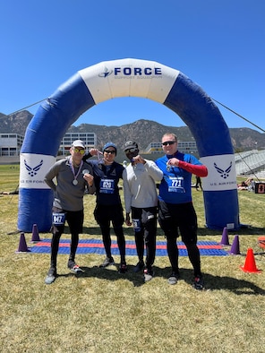 Four people stand at race finish line