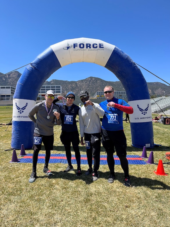 Four people stand at race finish line