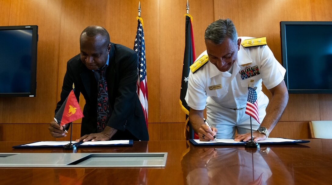 Dr. Andrew Moutu, director of the Papua New Guinea National Museum and Art Gallery (NMAG), left and U.S. Navy Rear Adm. Darius Banaji, deputy director for operations for the Defense POW/MIA Accounting Agency (DPAA) sign a Memorandum of Understanding (MOU) during a Papua New Guinea operations summit hosted by DPAA on Joint Base Pearl Harbor-Hickam, Hawaii, May 13, 2022. Papua New Guinea National Museum Art Gallery (NMAG) is one of the long-term host nation government partners that assists DPAA in the search for missing U.S. service members. The NMAG has assisted DPAA for over 25 years through contributing to the return and identification of and returning over 320 U.S. service members, which attests to the strong cooperation forged from years of working together on this noble mission. DPAA’s mission is to achieve the fullest possible accounting for missing and unaccounted-for U.S. personnel to their families and our nation. (U.S. Air Force photo by Tech. Sgt. Rusty Frank)