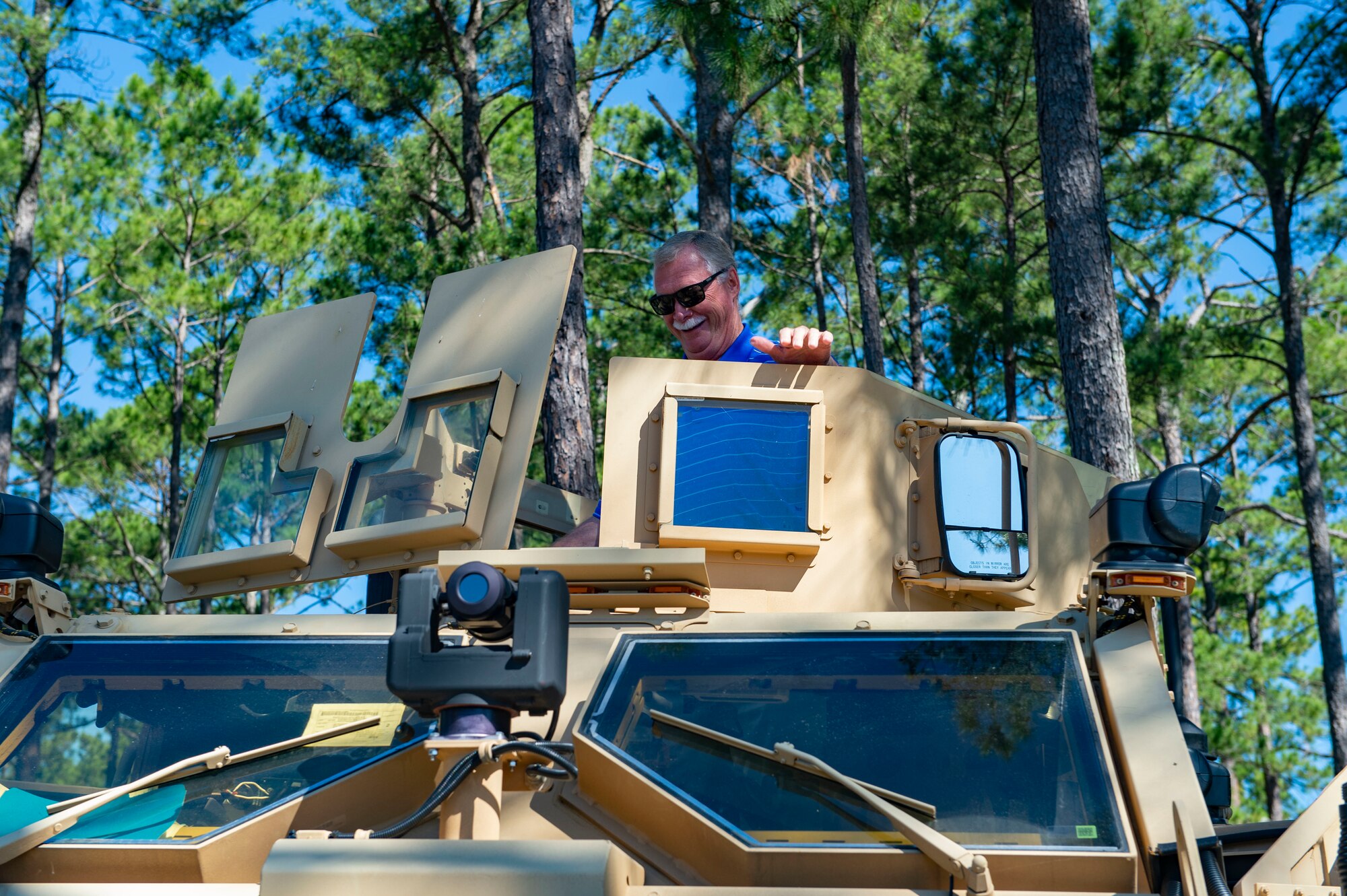 man sitting on top of a military vehicle