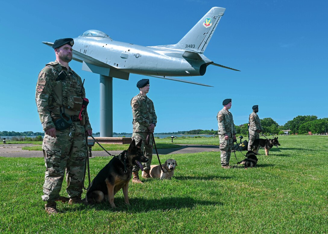 633d Security Forces Squadron Military Working Dog handlers stand in formation with their MWDs during the opening ceremony of National Police Week at Joint Base Langley-Eustis, Virginia, May 16, 2022.