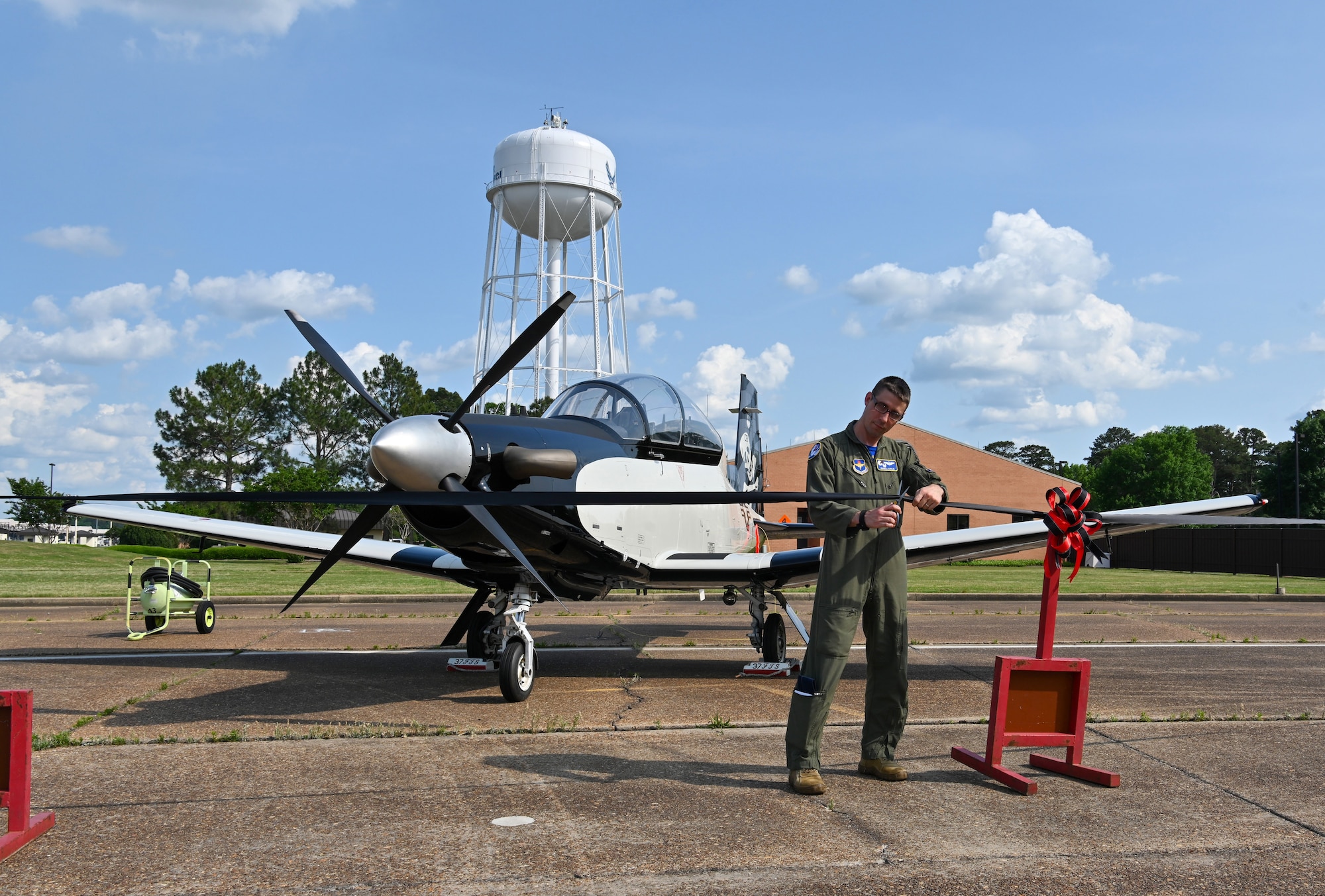 Lt. Col. Russel Kirkland, 41st Flying Training Squadron commander, cuts the ribbon of a heritage painting for the T-6A Texan II on May 13, 2022, at Columbus Air Force Base, Miss. FAIPs instruct in the T-6, T-38C Talon, or T-1A Jayhawk. (U.S. Air Force photo by Senior Airman Davis Donaldson)