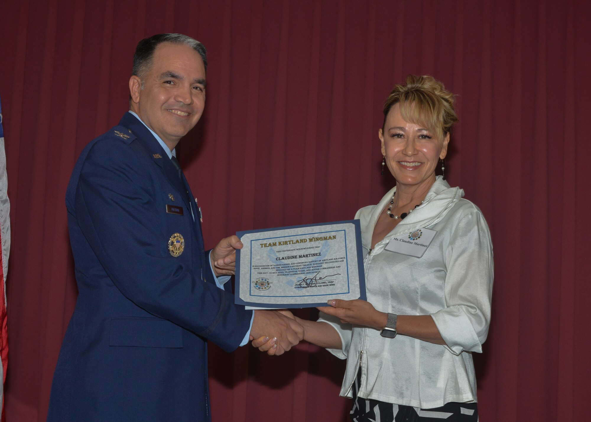 A man and woman hold a certificate and pose for a photo.