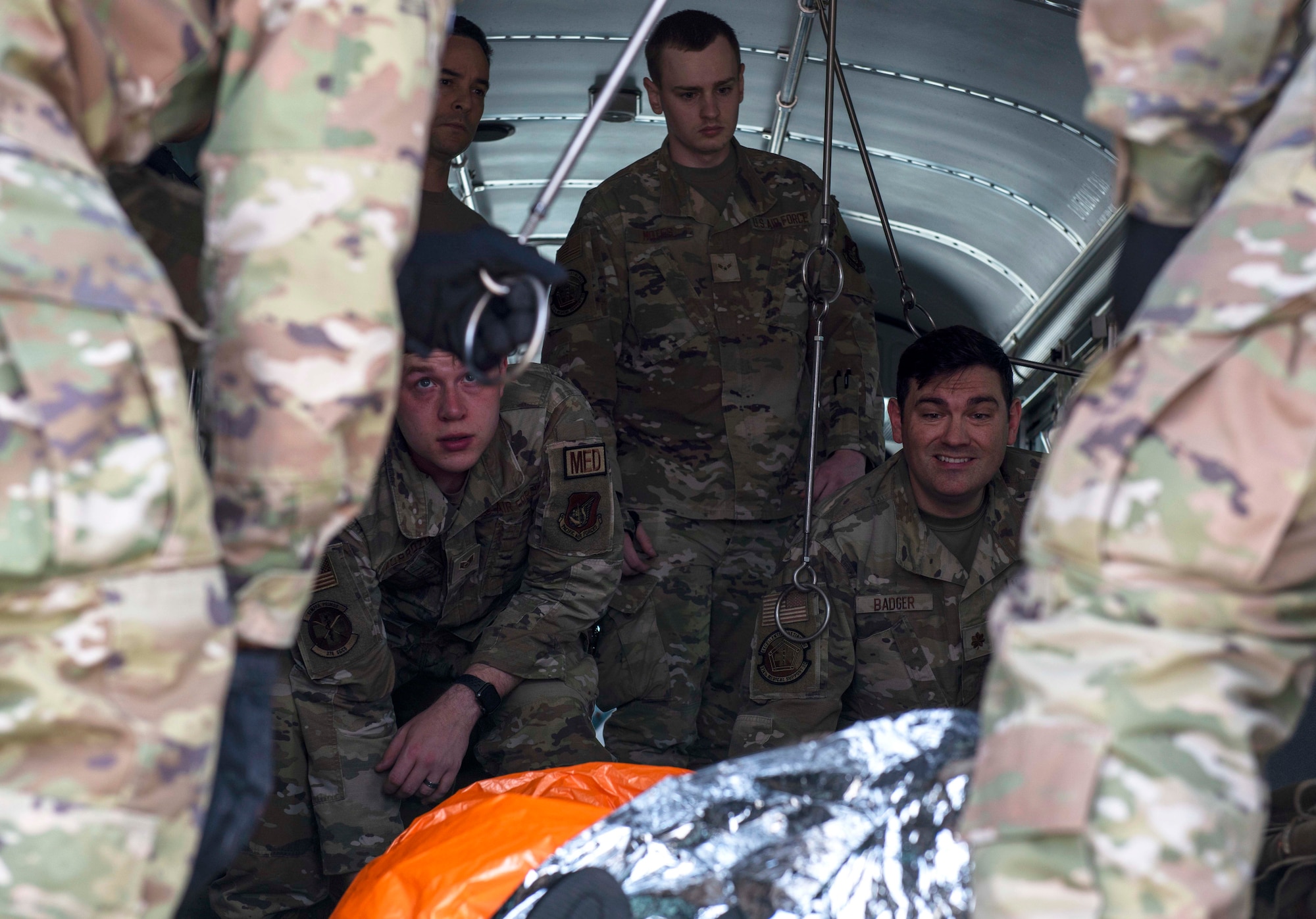 Airmen transport mock patients onto a C-130J Super Hercules