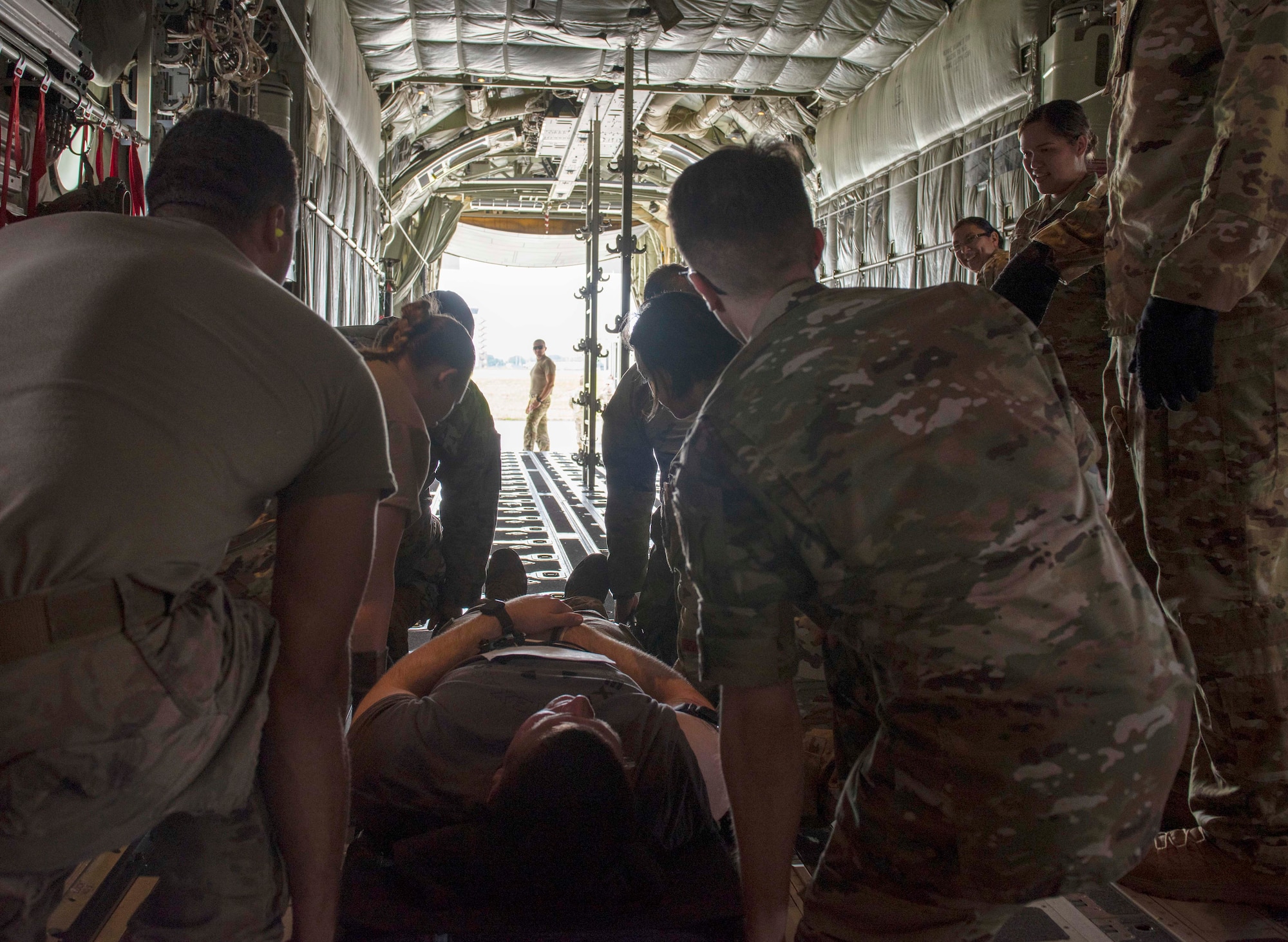 Airmen prepare to transport a mock patient off a C-130J Super Hercules