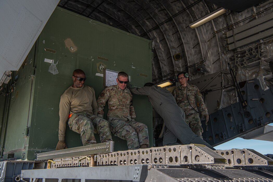 U.S. Air Force Airmen load cargo onto a C-17 Globemaster III from Joint Base Lewis-McChord, Washington, as part of Exercise Raging Gunfighter at Mountain Home Air Force Base, Idaho, May 17, 2022. Raging Gunfighter is an Air Combat Command (ACC) exercise designed to simulate the 366th Fighter Wing operating as a lead wing from a remote environment. (U.S. Air Force photo by Airman 1st Class Alexandria Byrd)