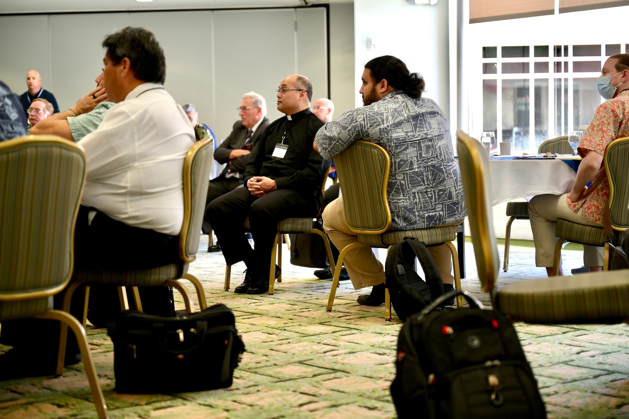 Attendees of a Cultural Religious Leader Engagement event listen to a brief by Col. Christopher LaPack, Pacific Air Forces command chaplain, at Joint Base Pearl Harbor-Hickam, Hawaii, May 12, 2022. Chaplain LaPack not only briefed on the role of spirituality as part of comprehensive Airman fitness, but the partnerships the PACAF chaplain team has with countries throughout the Indo-Pacific. (U.S. Air Force photo by 1st Lt. Benjamin Aronson)