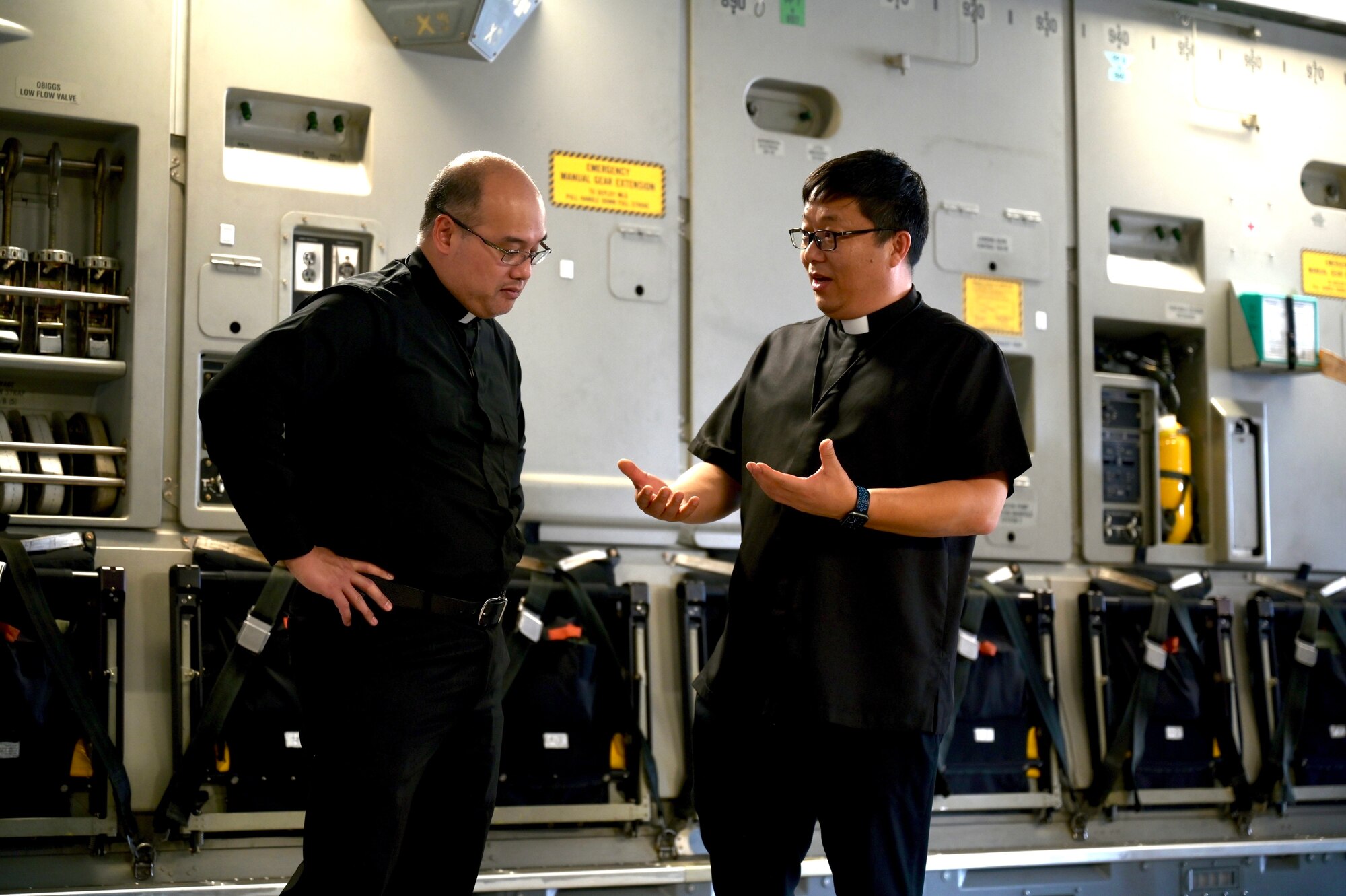 Father Rheo Ofalsa, Holy Family Catholic Church pastor, talks with Father Paul Li, Saint Philomena Church pastor, aboard a C-17 Globemaster III static display during a Cultural Religious Leader Engagement event at Joint Base Pearl Harbor-Hickam, Hawaii, May 12, 2022. The 647th Air Base Group Chaplain Corps held the event to strengthen ties between JBPHH and the local religious community. (U.S. Air Force photo by 1st Lt. Benjamin Aronson)