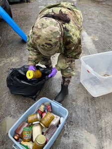 Alaska Army Guard Pvt. Frederica Rivers, a food service specialist with the 207th Engineer Utilities Detachment, sorts through salvageable food while assisting with cleanup and flood recovery efforts in Manley Hot Springs May 12, 2022.