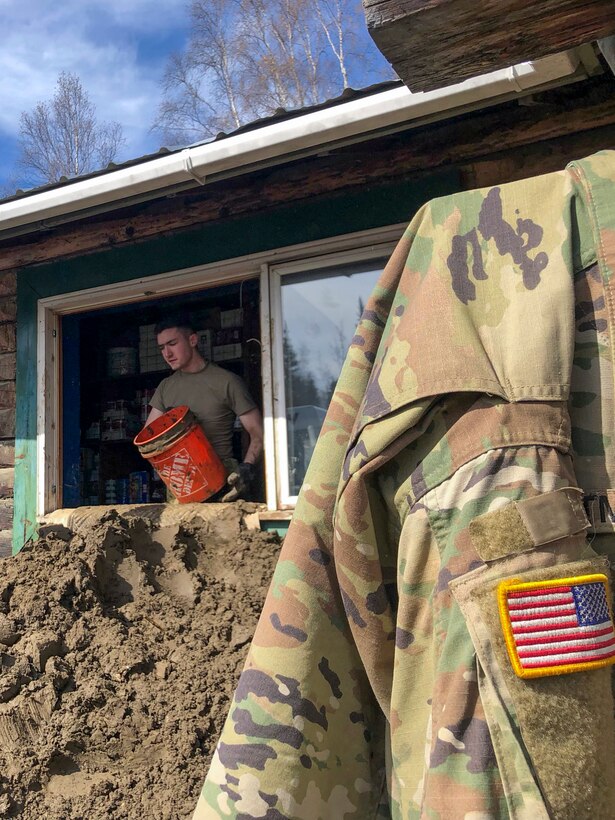 Alaska Army Guard Pfc. Harlan Hartman, a military policeman with the 297th Military Police Company, assists with cleanup and flood recovery efforts in Manley Hot Springs May 12, 2022. The State Emergency Operations Center requested the AKNG for support following a state disaster declaration on May 7 for the Yukon Koyukuk Regional Education Attendance Area.