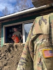 Alaska Army Guard Pfc. Harlan Hartman, a military policeman with the 297th Military Police Company, assists with cleanup and flood recovery efforts in Manley Hot Springs May 12, 2022. The State Emergency Operations Center requested the AKNG for support following a state disaster declaration on May 7 for the Yukon Koyukuk Regional Education Attendance Area.