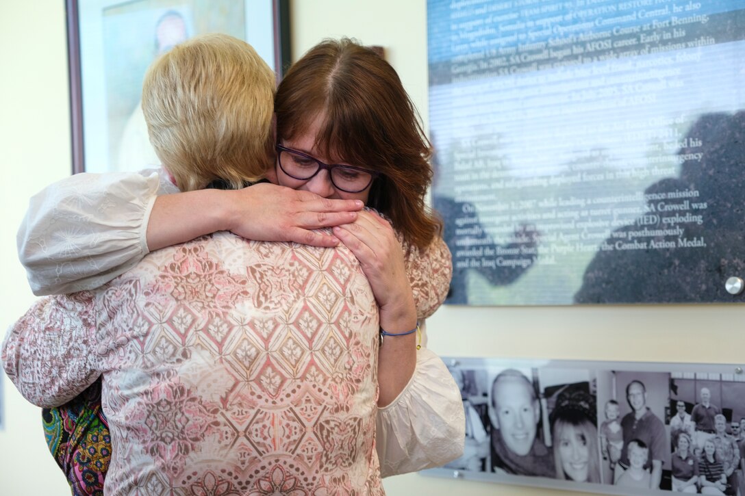 Family members share a moment during the Celebration of Life event at the Office of Special Investigations headquarters Hall of Heroes, at Quantico, Va., May 17, 2022. The Hall is lined with photos of Fallen OSI Special Agents, a professional staff member and two Security Forces defenders who were killed in the line of duty representing OSI. (U.S. Air Force photo by Staff Sgt. Joshua King)