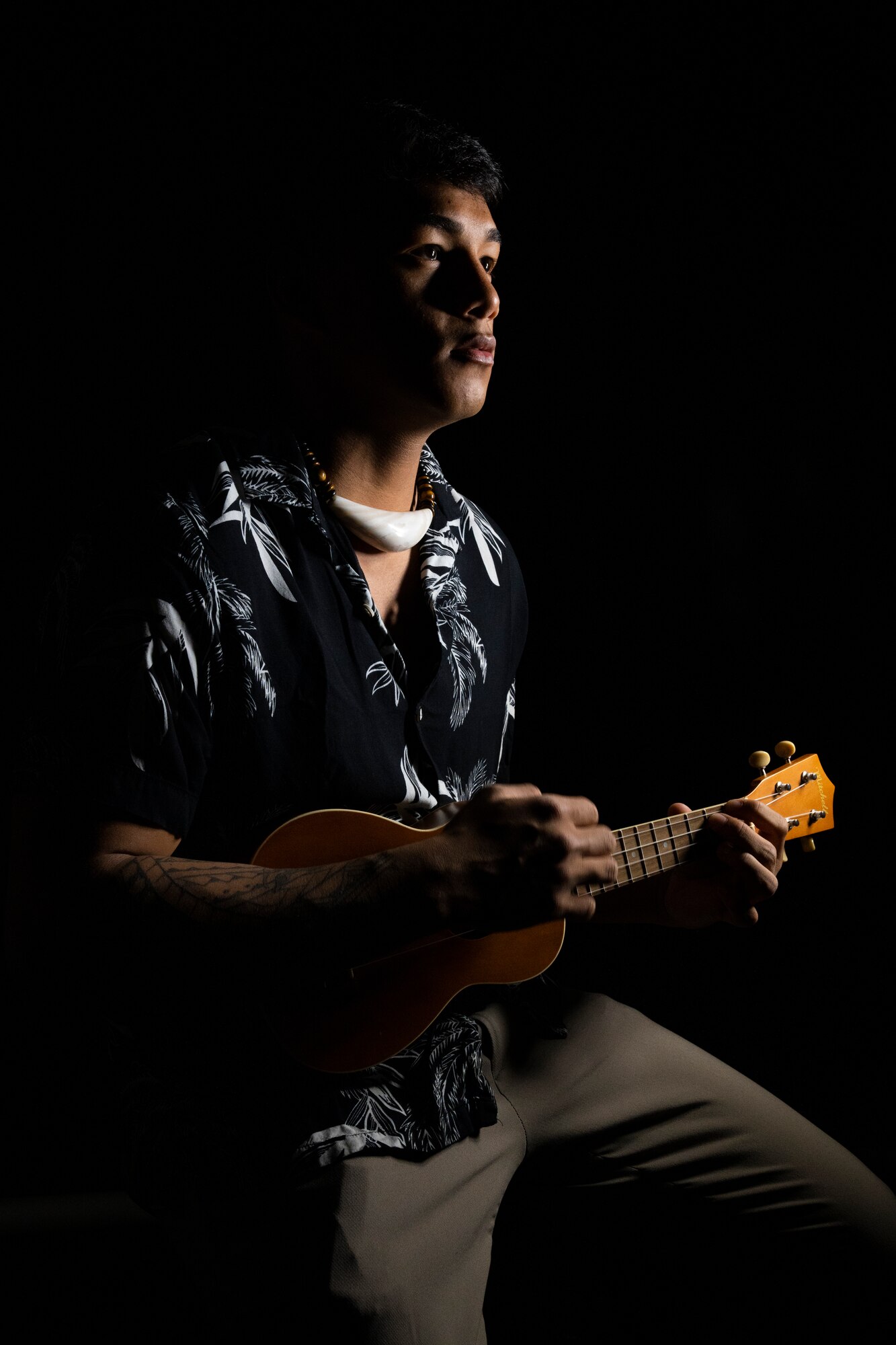 A young man playing the ukulele