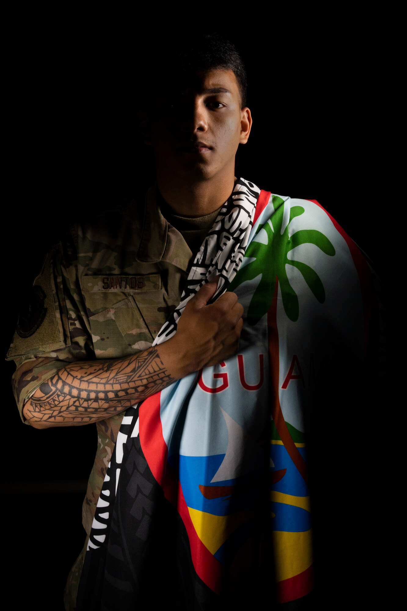 A young man holding a rendition of the Guam National Flag