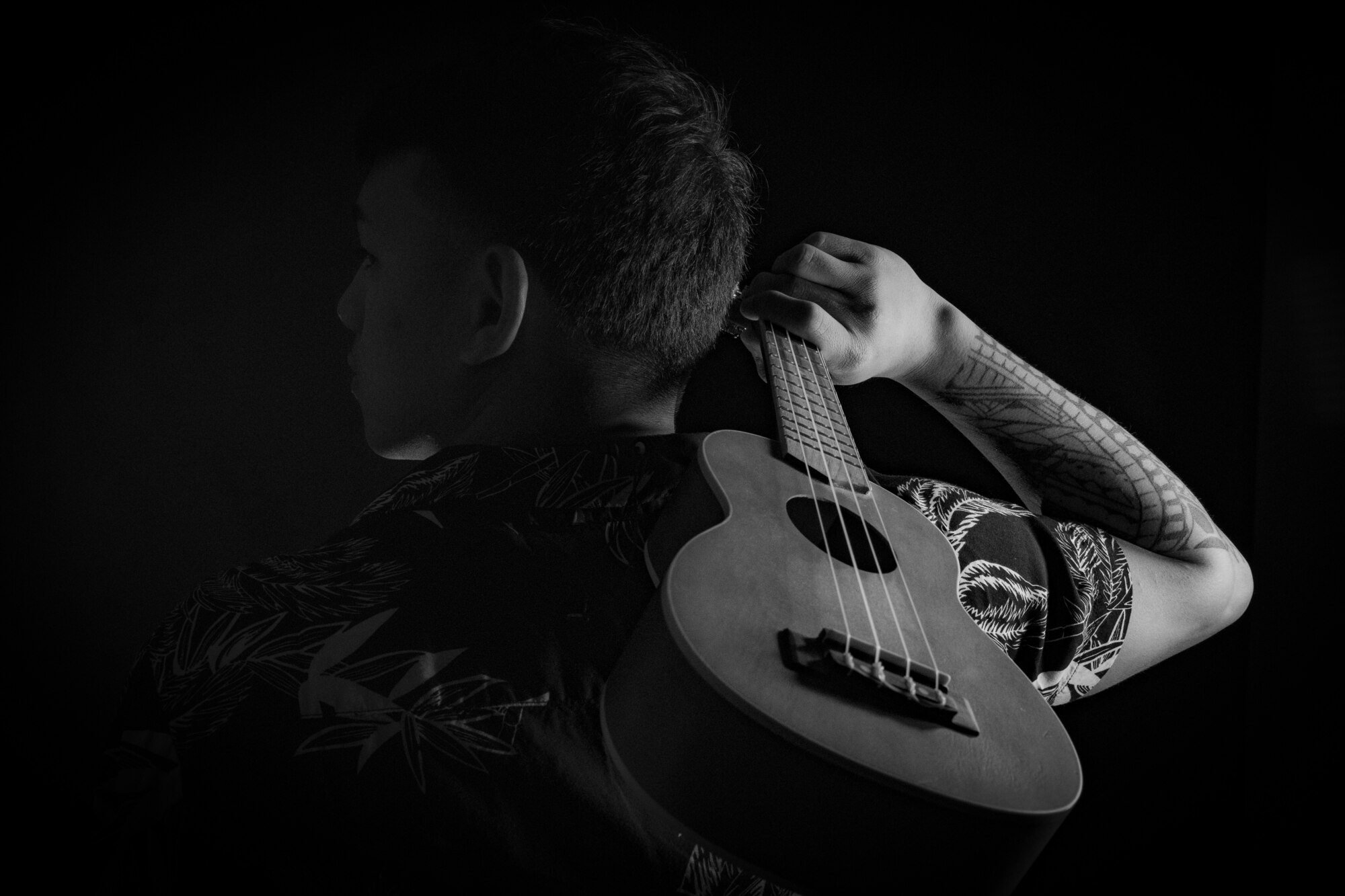 A young man holding a ukulele