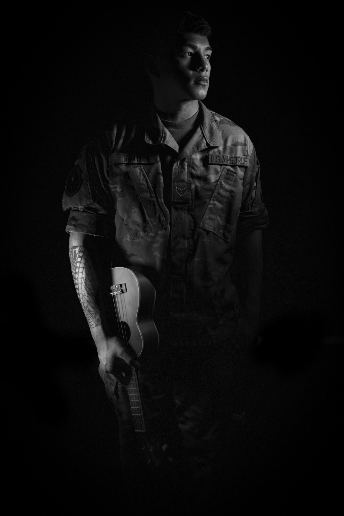 A young man holding a ukulele